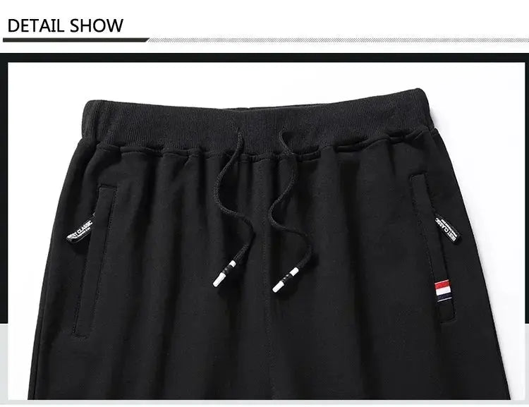 Simples Market men's black track pants with elastic waistband, drawstring, and zip pockets.
