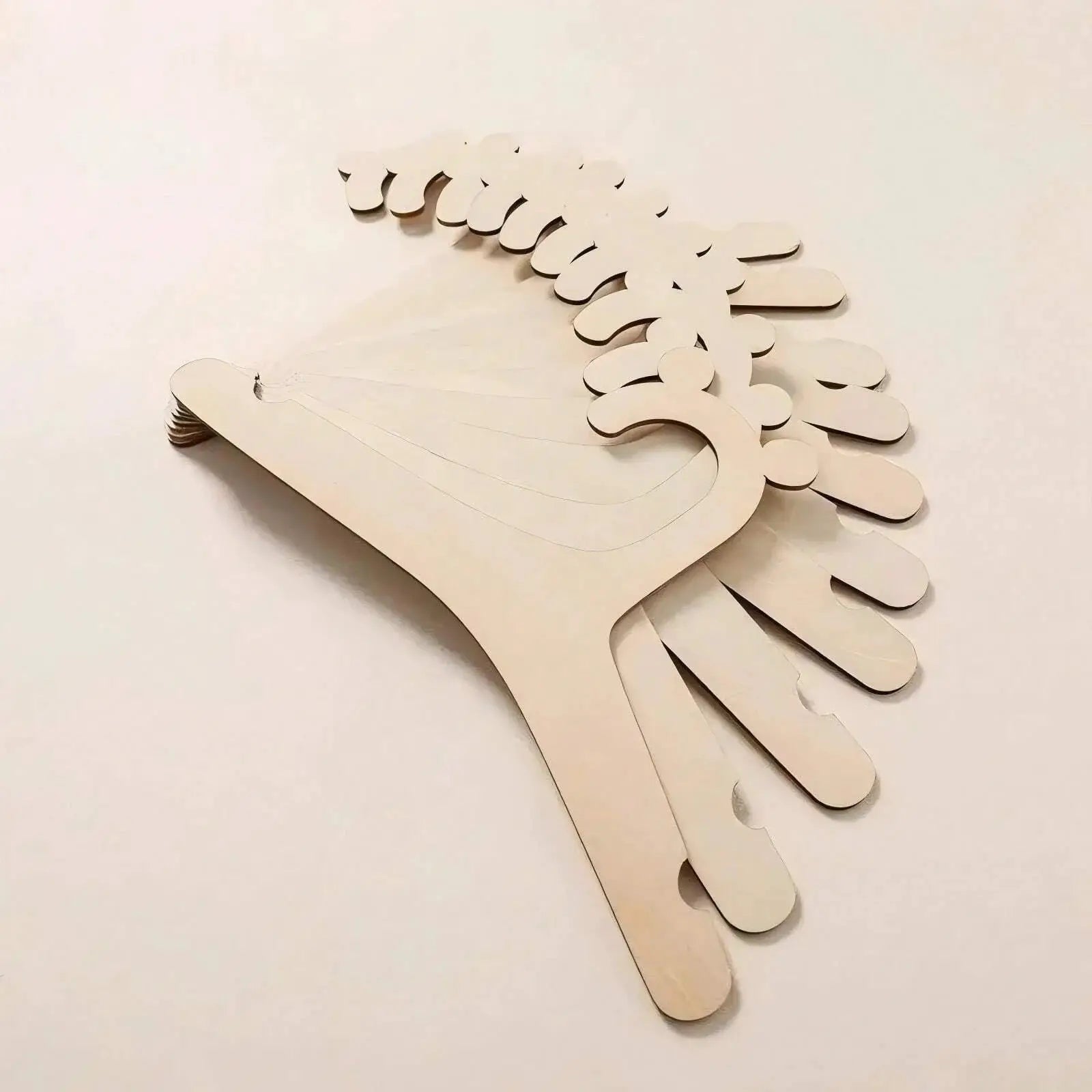 Bear-shaped wooden baby clothes hangers in white; kid-friendly nursery decor by Simples Market