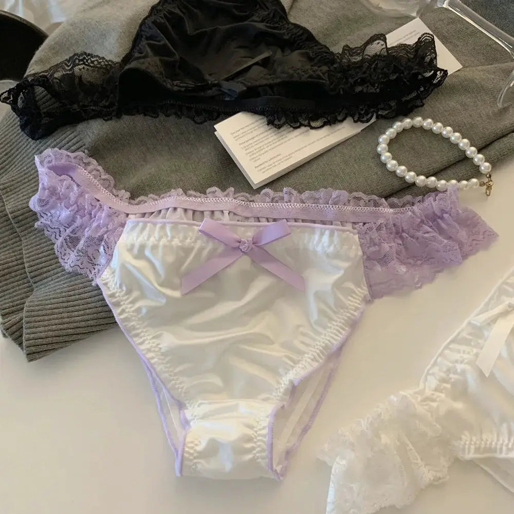 Two women's panties: lavender satin with lilac lace trim and bow, plus black lace panty.