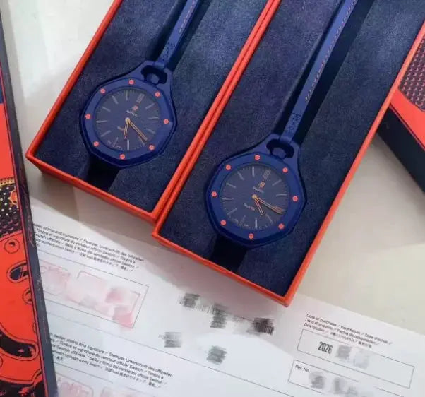 Pair of blue AP Swatch joint watches in orange gift boxes with orange markers.
