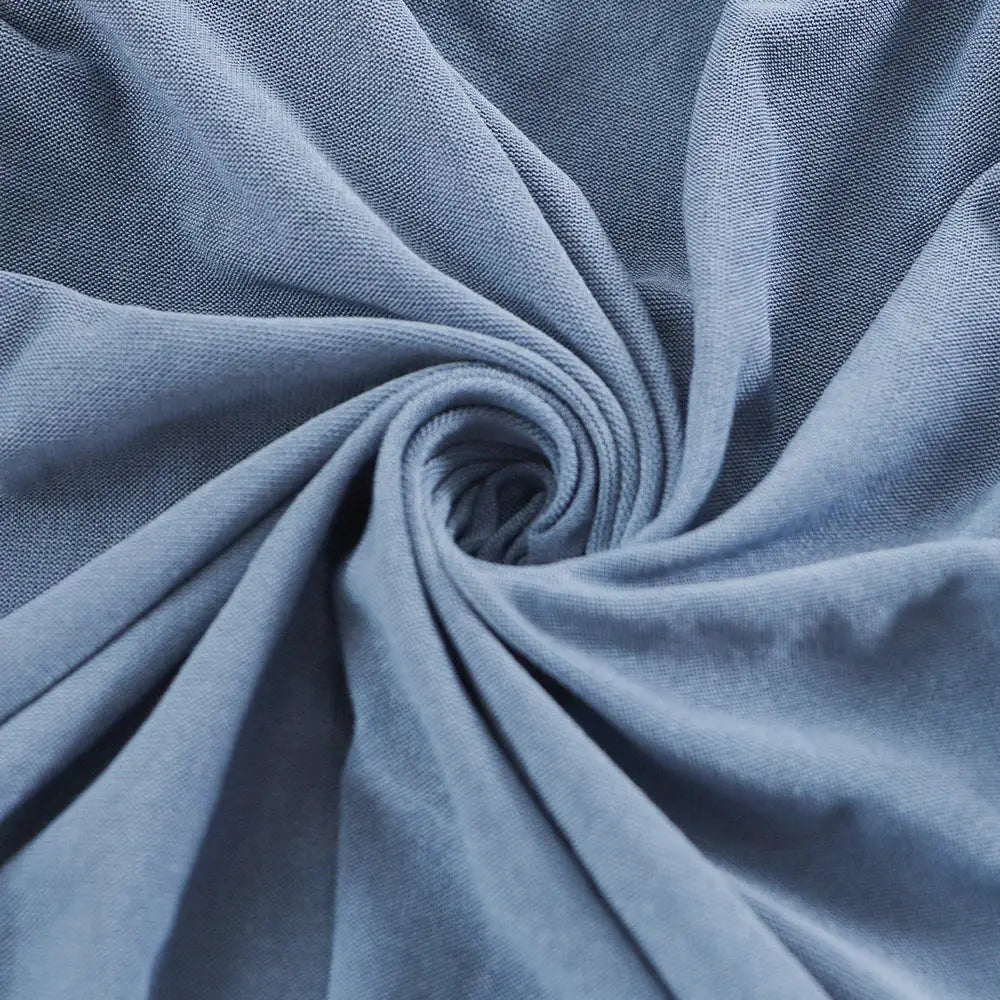 Outdoor elastic sofa cover in solid blue fabric for garden patio cushions.