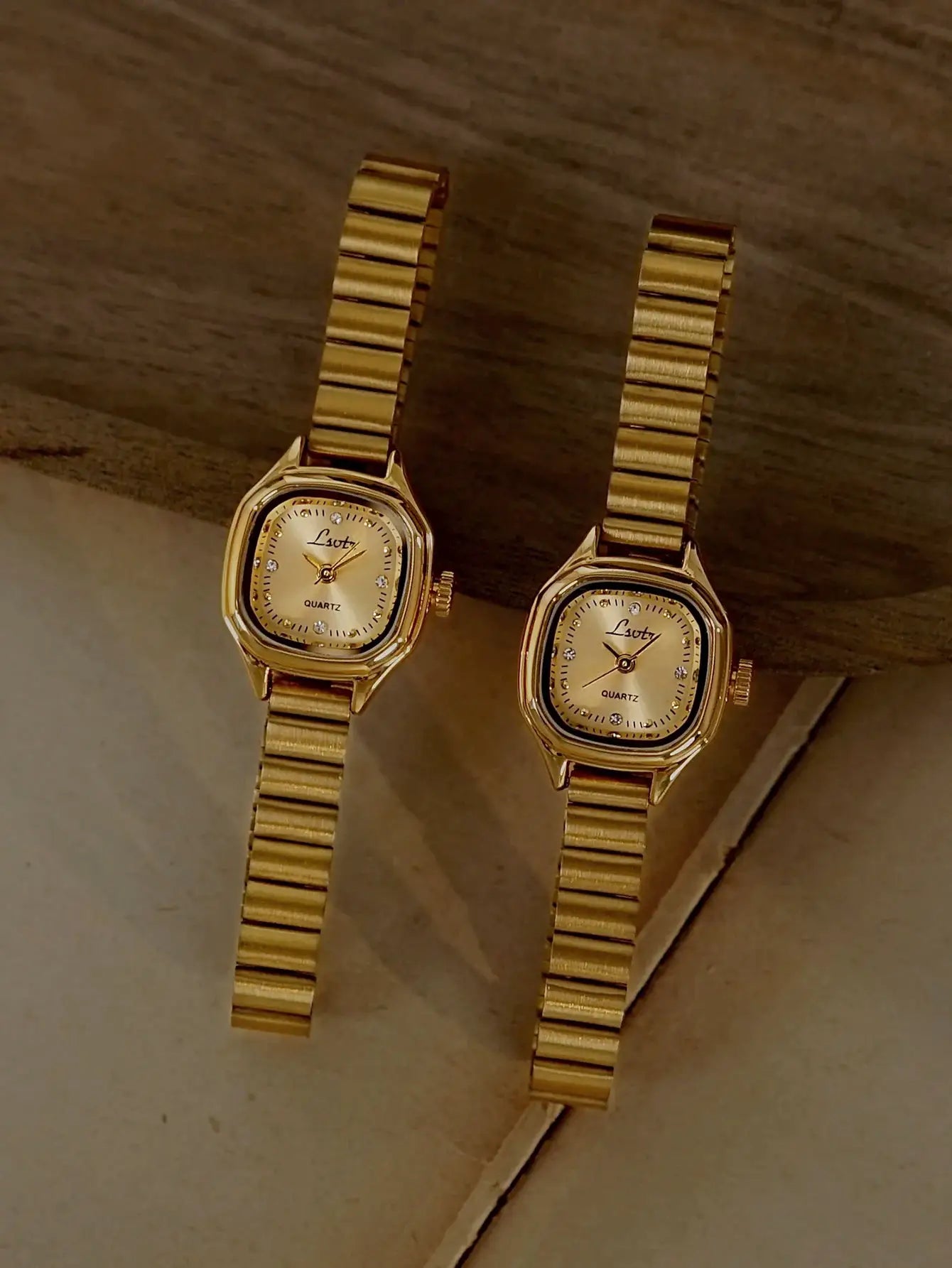 Two gold-tone square-dial women's quartz watches with stainless steel link bracelets