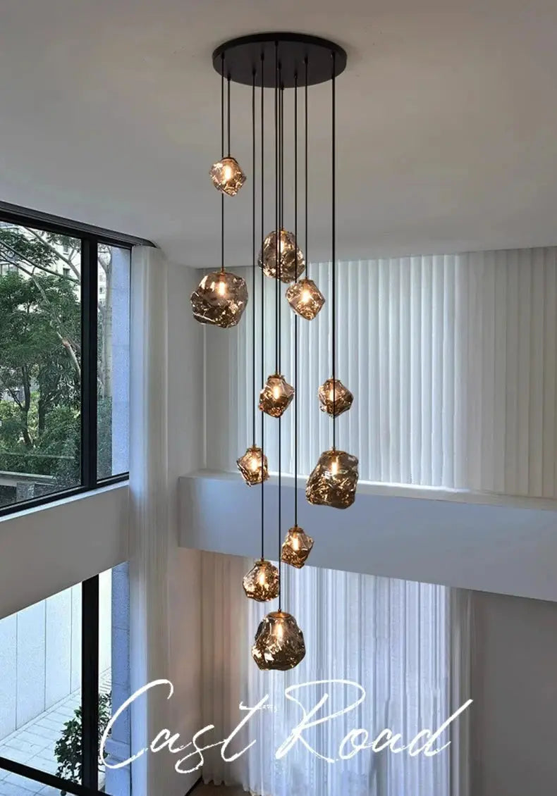 Modern pendant light fixture with multiple amber glass geometric bulbs on black cords, ceiling mount for living room decor