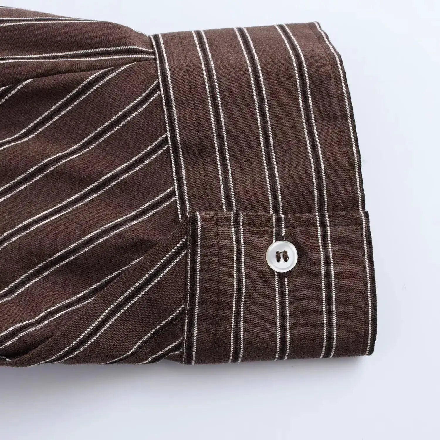 Simples Market brown striped shirt cuff with white vertical stripes and a white button