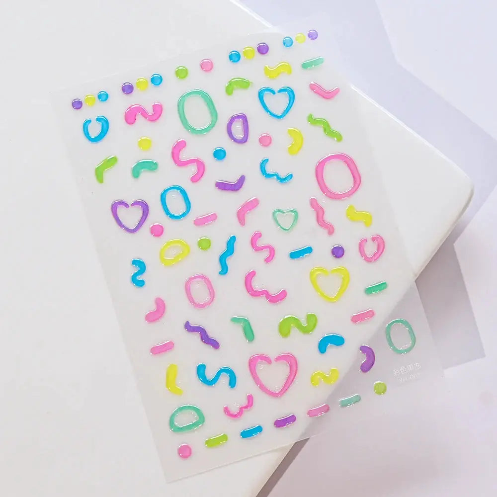 Nail art decal sheet with colorful heart, circle, oval and squiggle stickers in pink, blue, yellow, green and purple