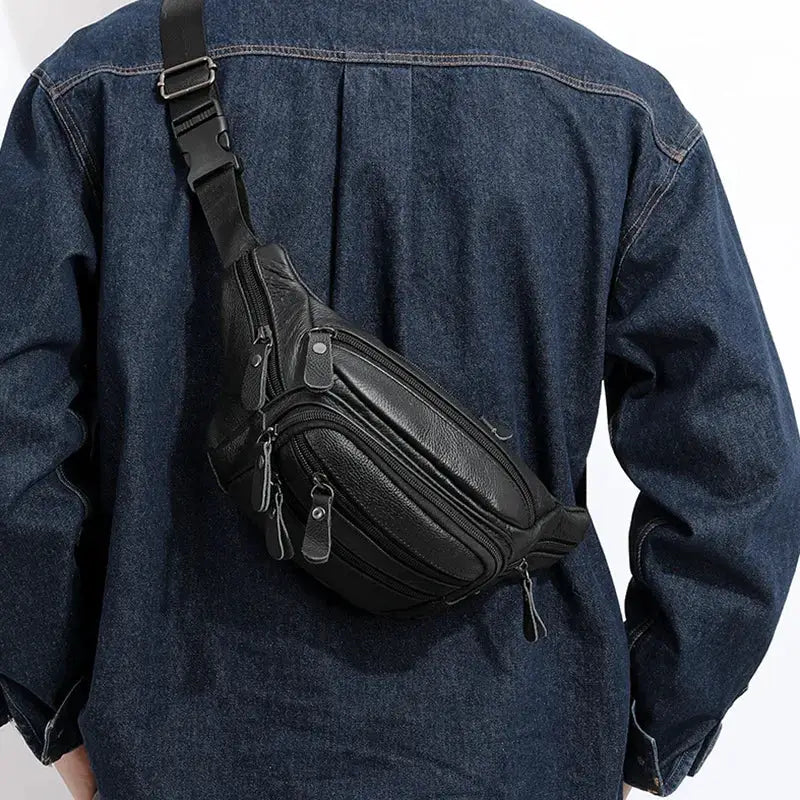 Men's genuine leather fanny pack in black with multiple zip pockets worn as a crossbody waist bag