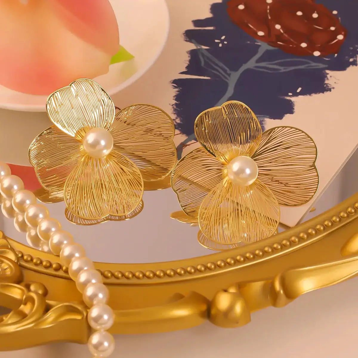Pair of large flower pearl earrings by Simples Market, gold-tone petals with pearl centers.