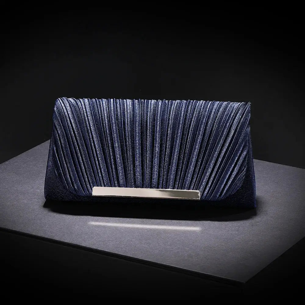 Evening clutch bag in navy blue with pleated sequined surface and silver bar clasp.