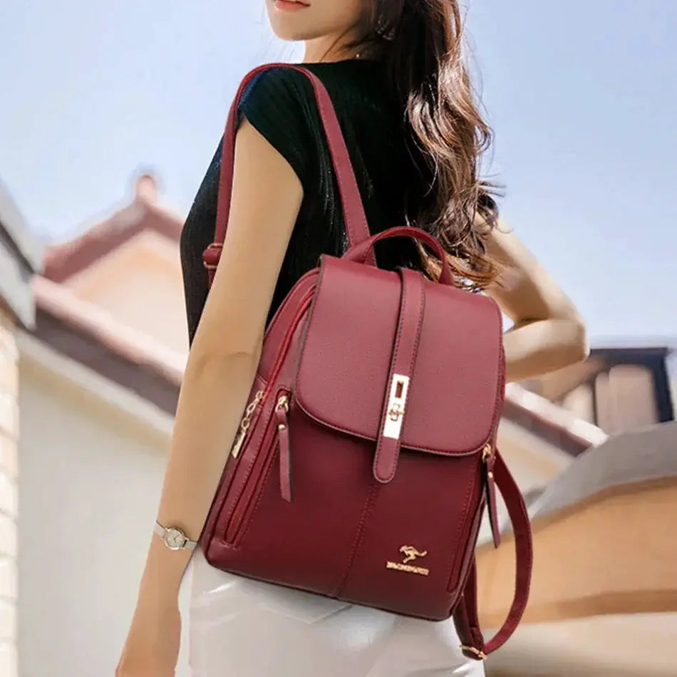 Women’s burgundy leather backpack by Simples Market, a large-capacity rucksack with gold hardware and front flap.