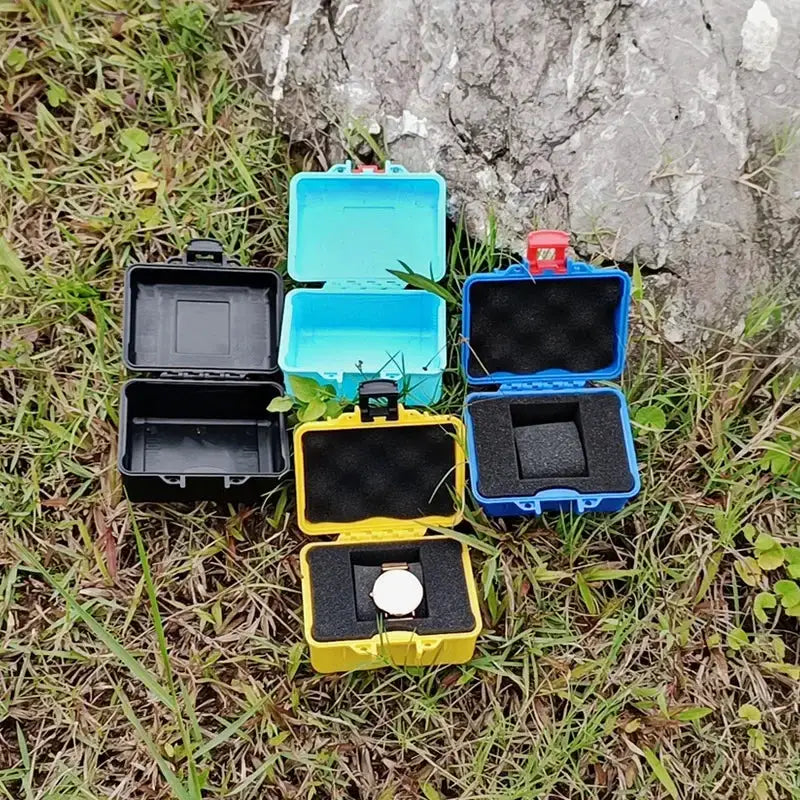 Six small PP tool boxes in black, cyan, blue, and yellow with foam inserts; one yellow box holds a watch