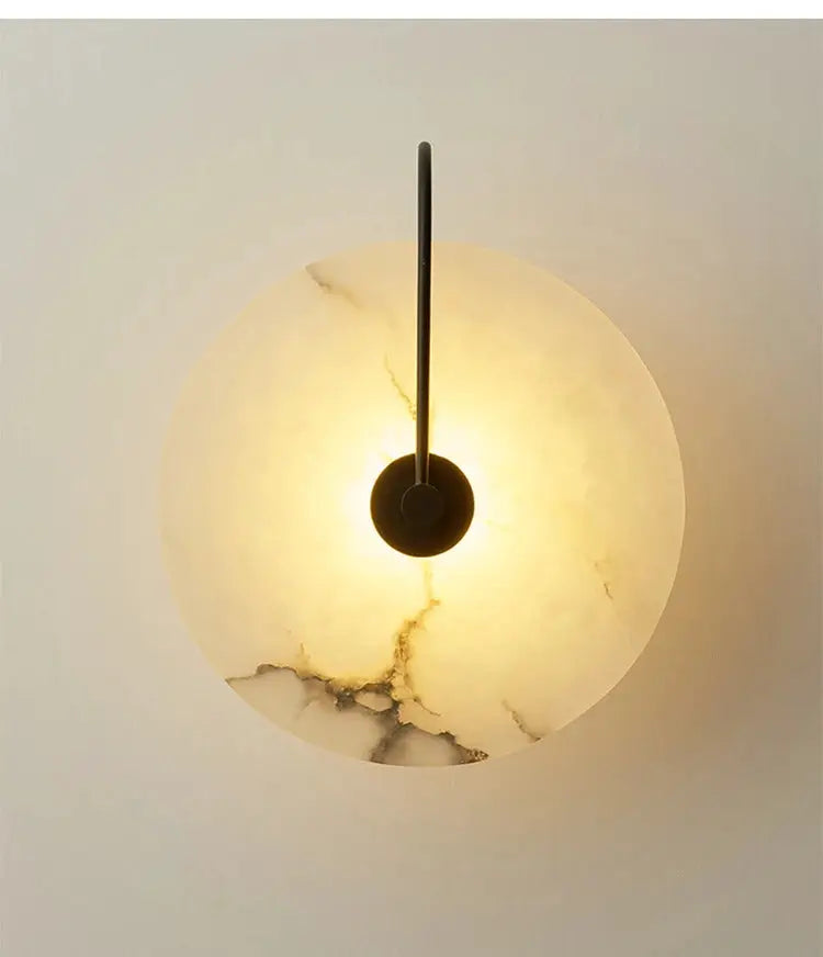 Marble moon wall sconce with warm LED glow and black metal rod by Simples Market