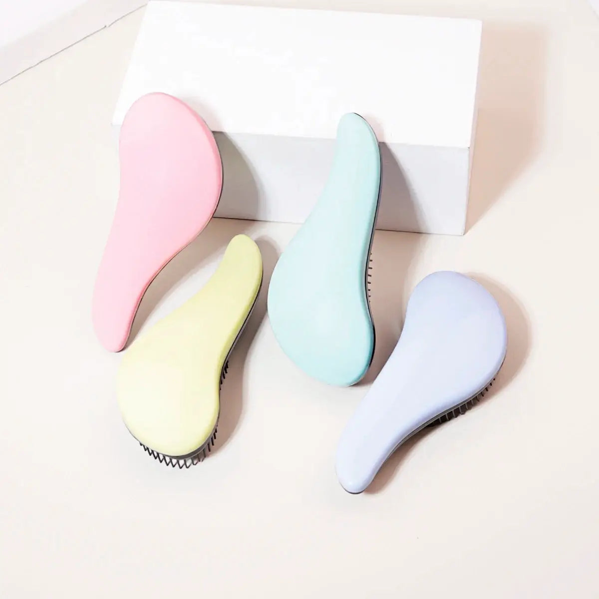 Antistatic massage brush set, four pastel curved detangling brushes.