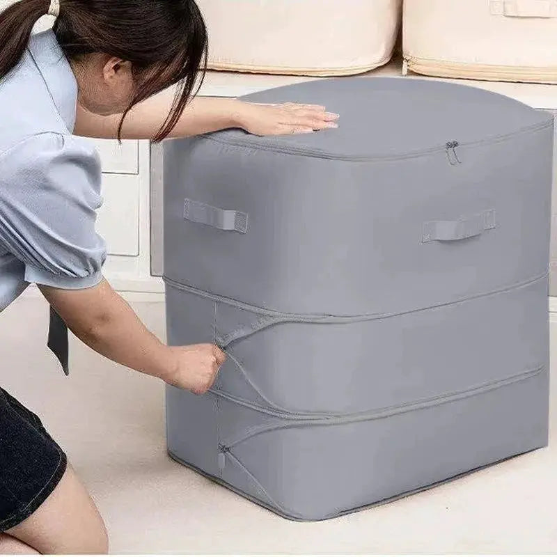 Heavy-Duty Self-Compressing Storage Bag, gray fabric with zip top and side handles for clothes and blankets.