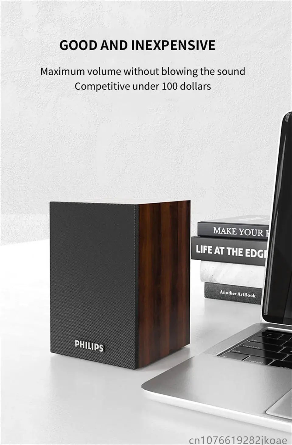 Philips SPA20 Bluetooth speaker with wood veneer sides and black front, placed beside a laptop on a desk.
