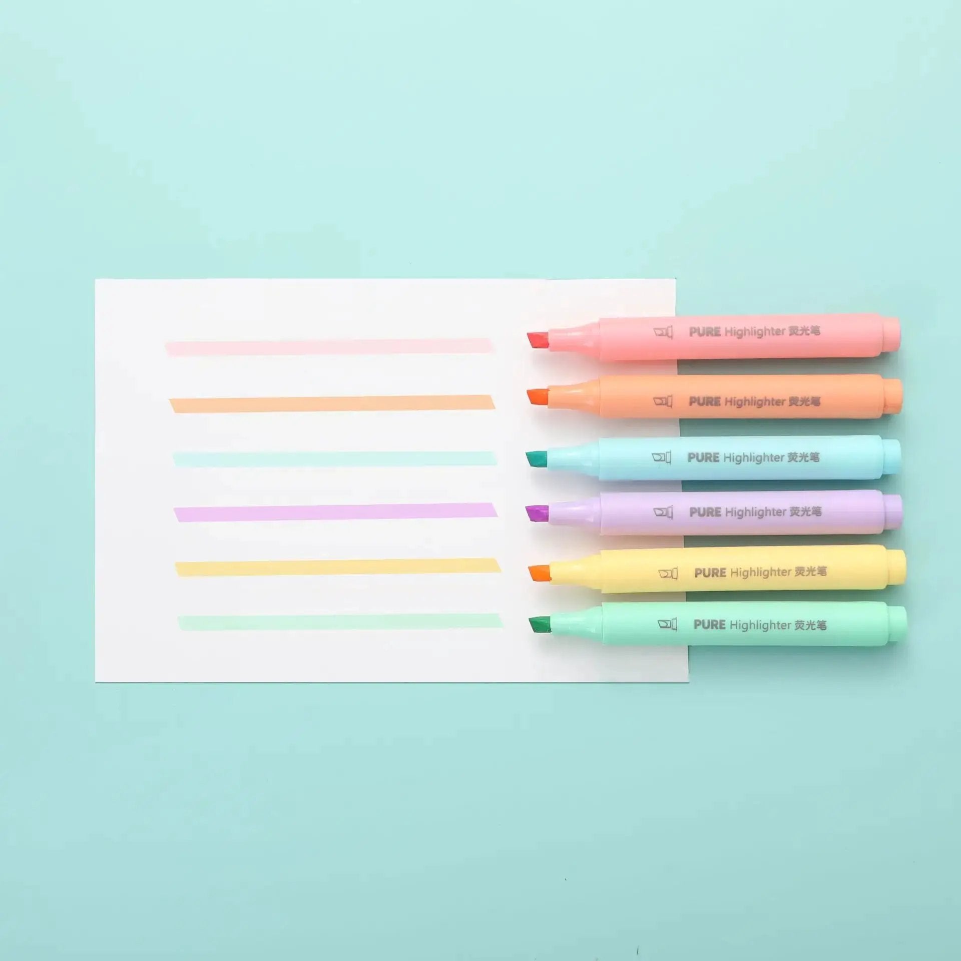 6-piece pastel macaron highlighter set in pink, peach, mint, lavender, yellow, and blue on a white sheet.