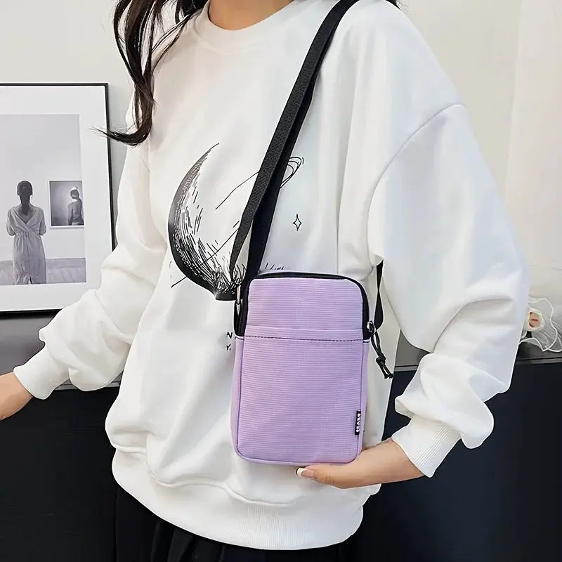 Shoulder bag by Simples Market; lavender vertical crossbody with black strap and front pocket