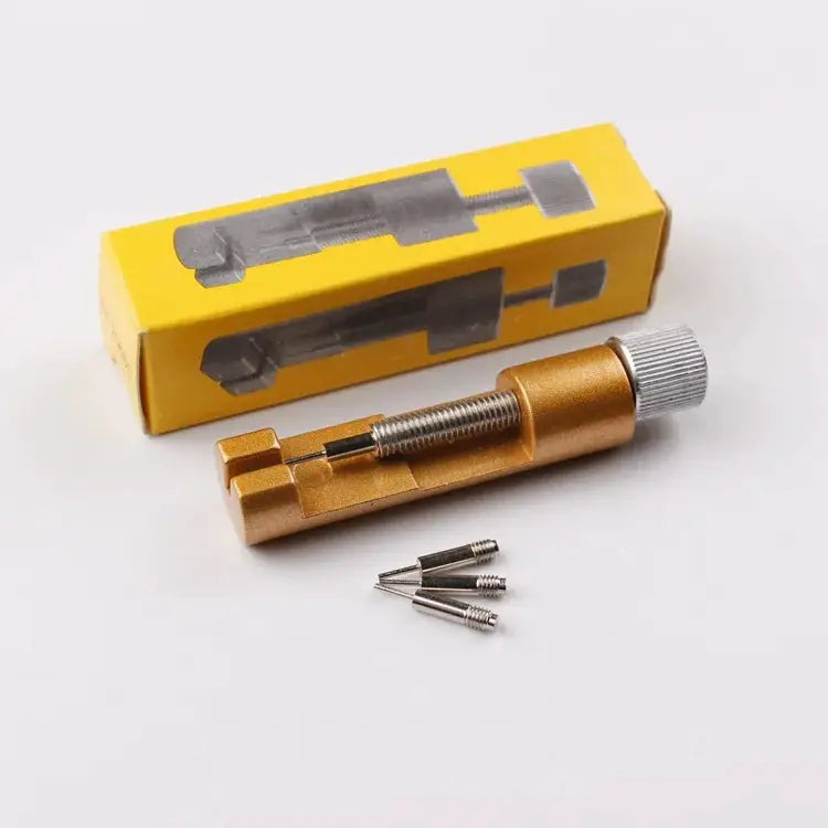 Gold metal watch band link pin remover tool with adjustable screw and three replacement pins.