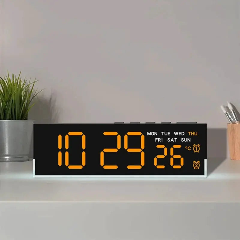 USB powered digital alarm clock with orange LED time on a black display and white base, weekday indicators on a desk.
