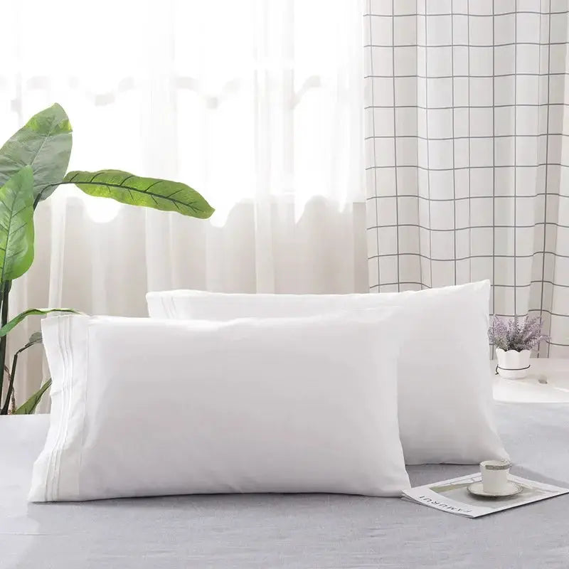 2-pack white pillowcases on a bed; soft, comfortable fabric, insert not included.