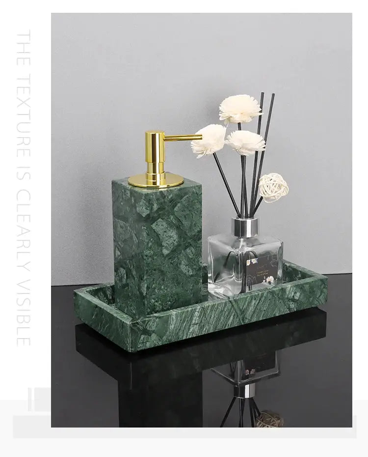 Green Indian natural marble bathroom set with gold soap dispenser and glass reed diffuser on a matching marble tray.