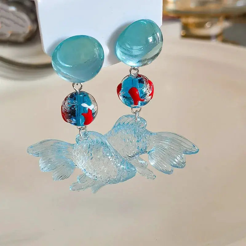 Simples Market goldfish drop earrings pair; turquoise studs with red/blue accents and a light blue koi pendant