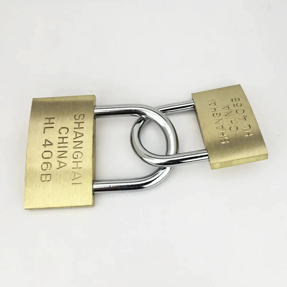 Two brass padlocks with chrome shackles interlocked; SHANGHAI CHINA engraved on bodies.