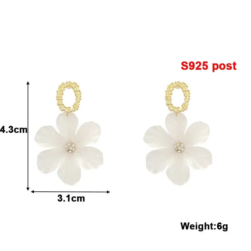 Pair of white flower dangle earrings with acrylic petals, rhinestone center, and gold-tone loop