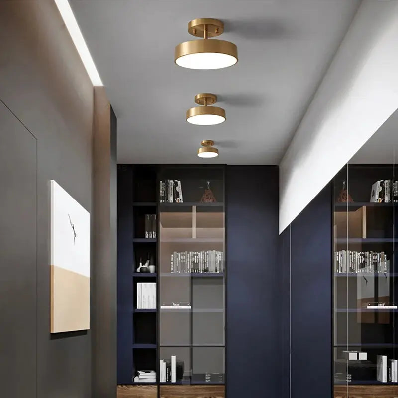Simples Market modern LED ceiling light; four copper round flush-mount fixtures in gold finish along a dark hallway.