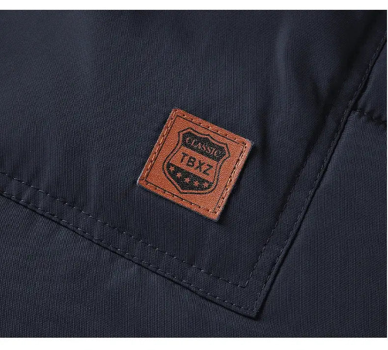 Men's navy parka jacket with brown leather patch detail.