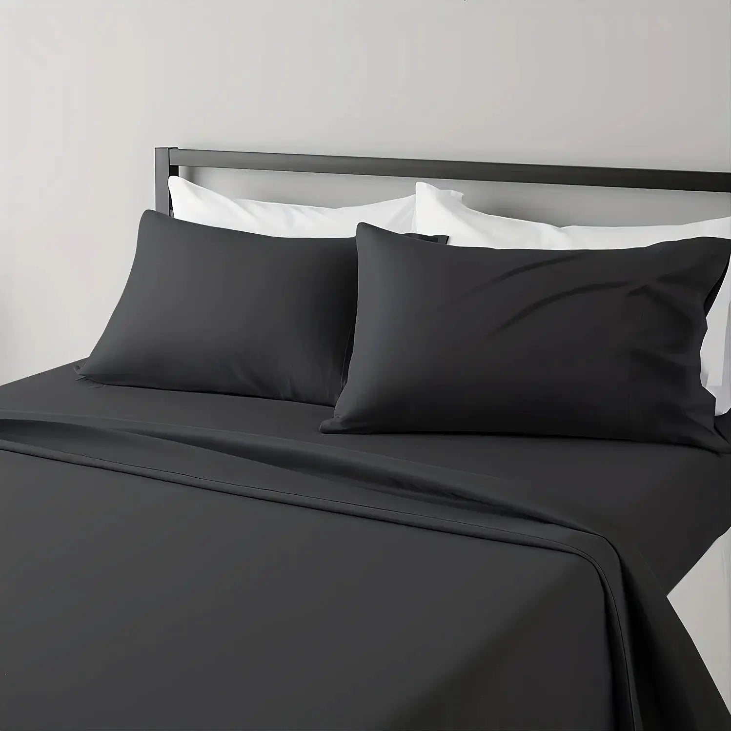 Sheet set in charcoal gray on bed with white pillowcases; breathable, hotel-style.