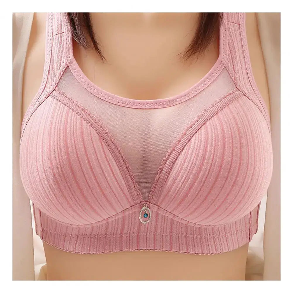 Women's pink wireless bra with wide straps, ribbed cups, breathable fabric, and a center charm pendant.