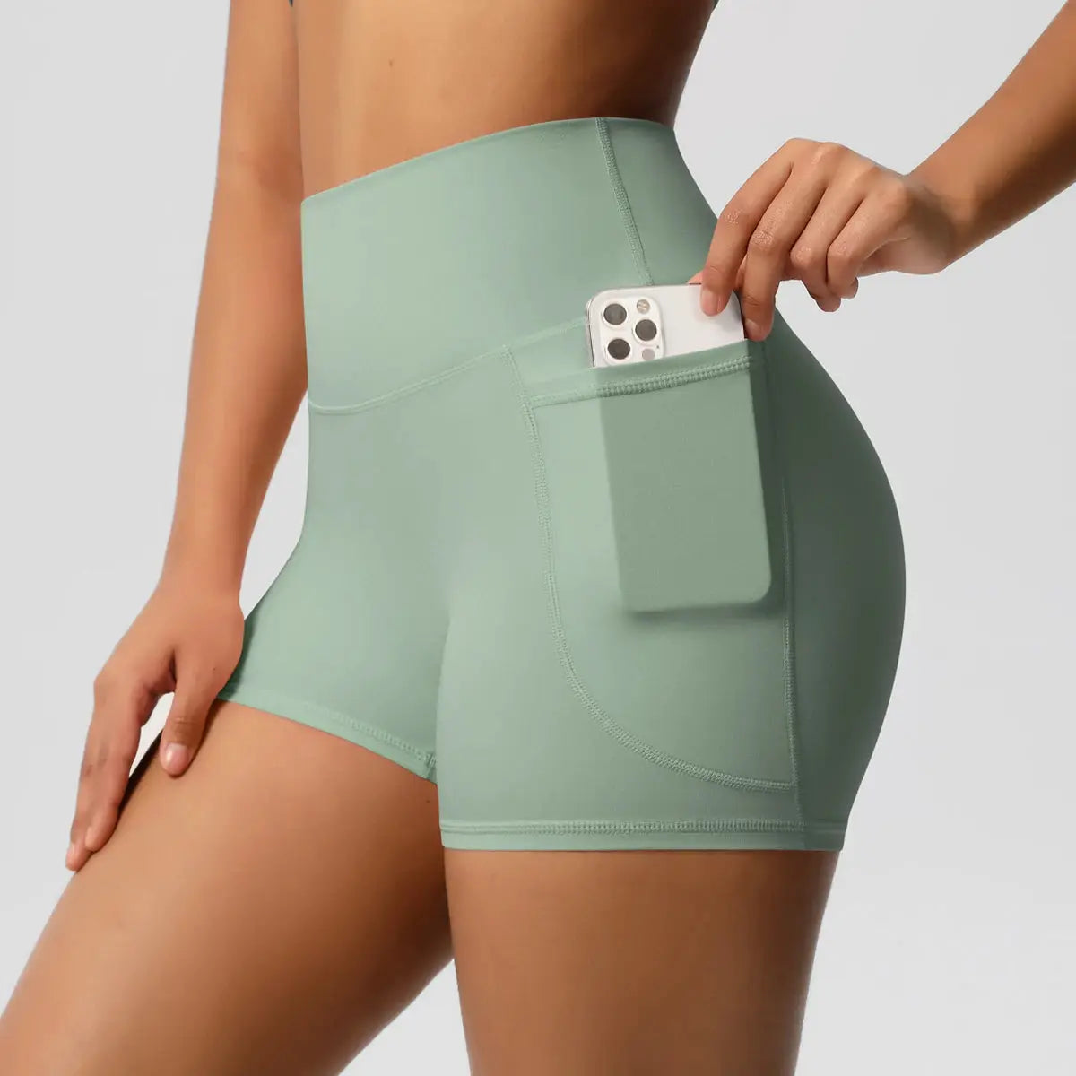 Simples Market Women’s high-waist pocketed yoga shorts in mint green with phone pocket.