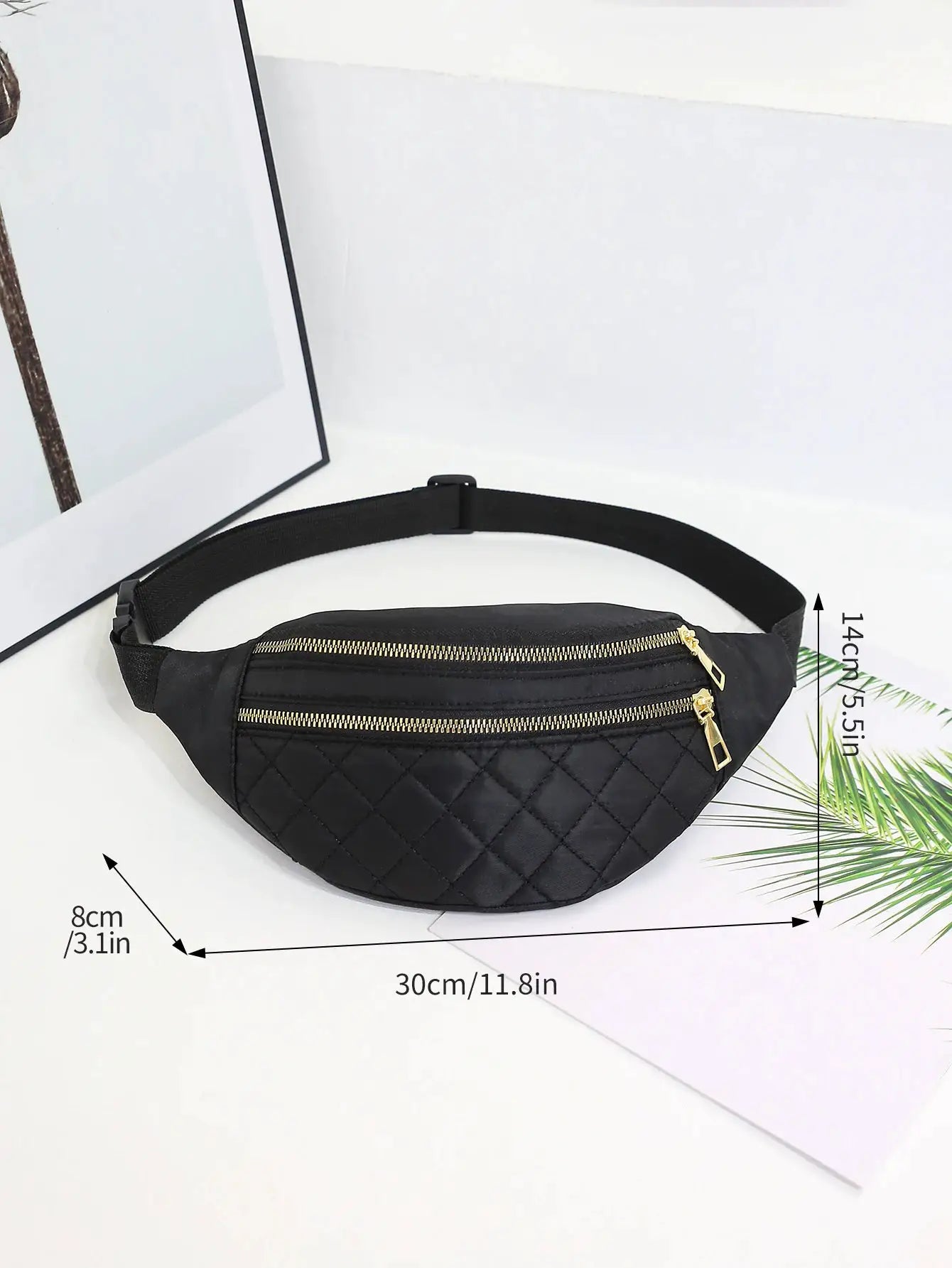 Black quilted waist bag with dual gold zippers and an adjustable strap.