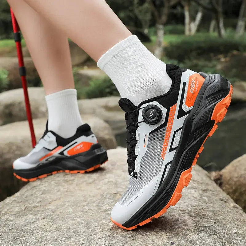 Pair of men's casual sneakers with white/gray upper, black accents and orange outsole.