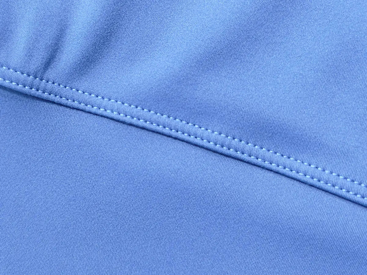Women's blue yoga shorts fabric close-up with reinforced double-stitched seam