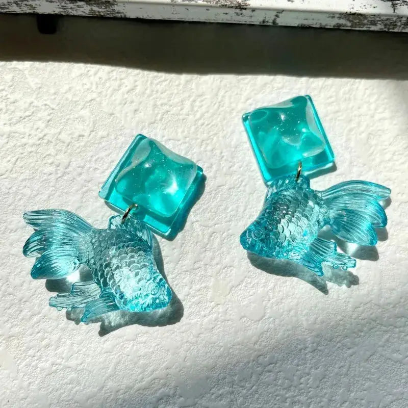 Pair of turquoise acrylic goldfish pendant drop earrings with translucent cube beads