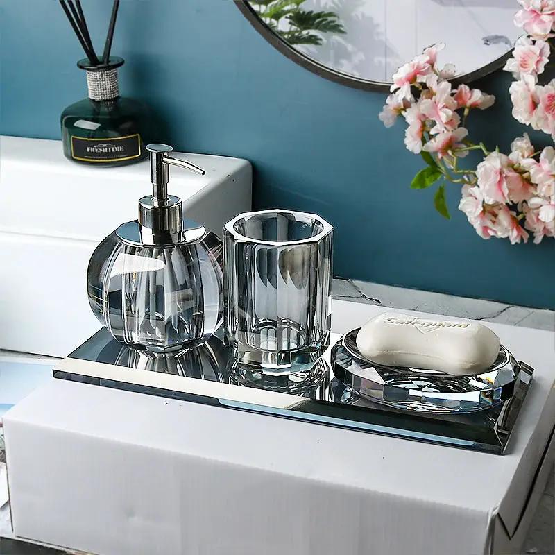 Glass bathroom set by Simples Market on a mirrored tray: 4pc clear dispenser, tumbler, toothbrush holder, soap dish