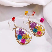 Teardrop epoxy resin earrings with colorful pressed flowers in gold-tone frame (pair) by Simples Market