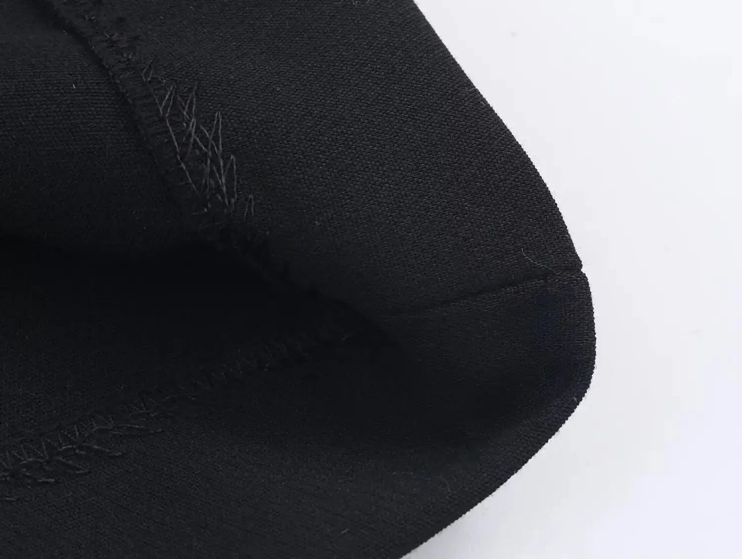 Women's black blazer sleeve close-up with visible stitching and seam details