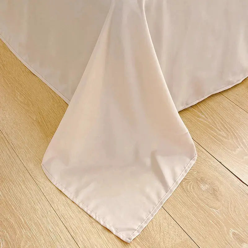 Duvet cover and four-piece washed cotton bed set in cream on a wooden floor