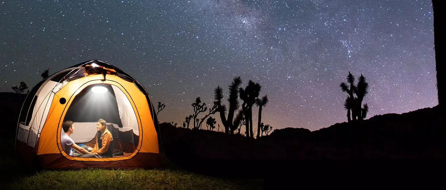LED Leaf camping lamp inside an orange tent with two campers under a starry night sky