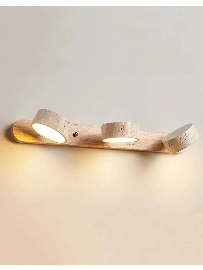 Three-round LED wall light on a natural wood plank with concrete cylinder heads
