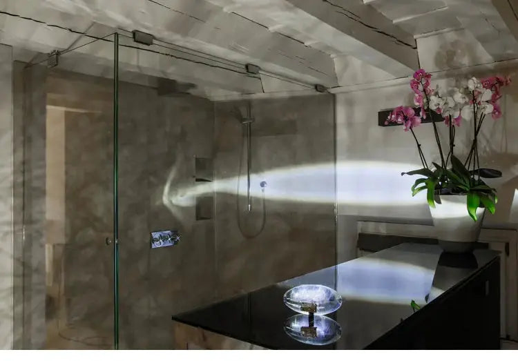 Egg-shaped LED crystal table lamp on a glossy black countertop in a modern bathroom.