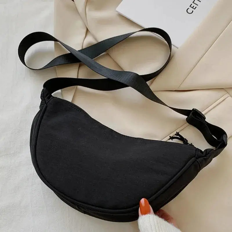 Nylon dumpling bag in black, a lightweight small crossbody/shoulder bag with an adjustable strap and slim silhouette.