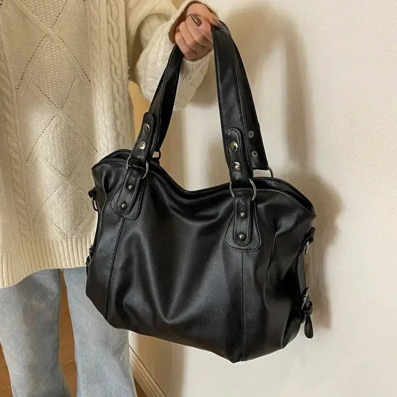 Shoulder bag in black PU leather with dual handles, zipper closure, and metal hardware by Simples Market