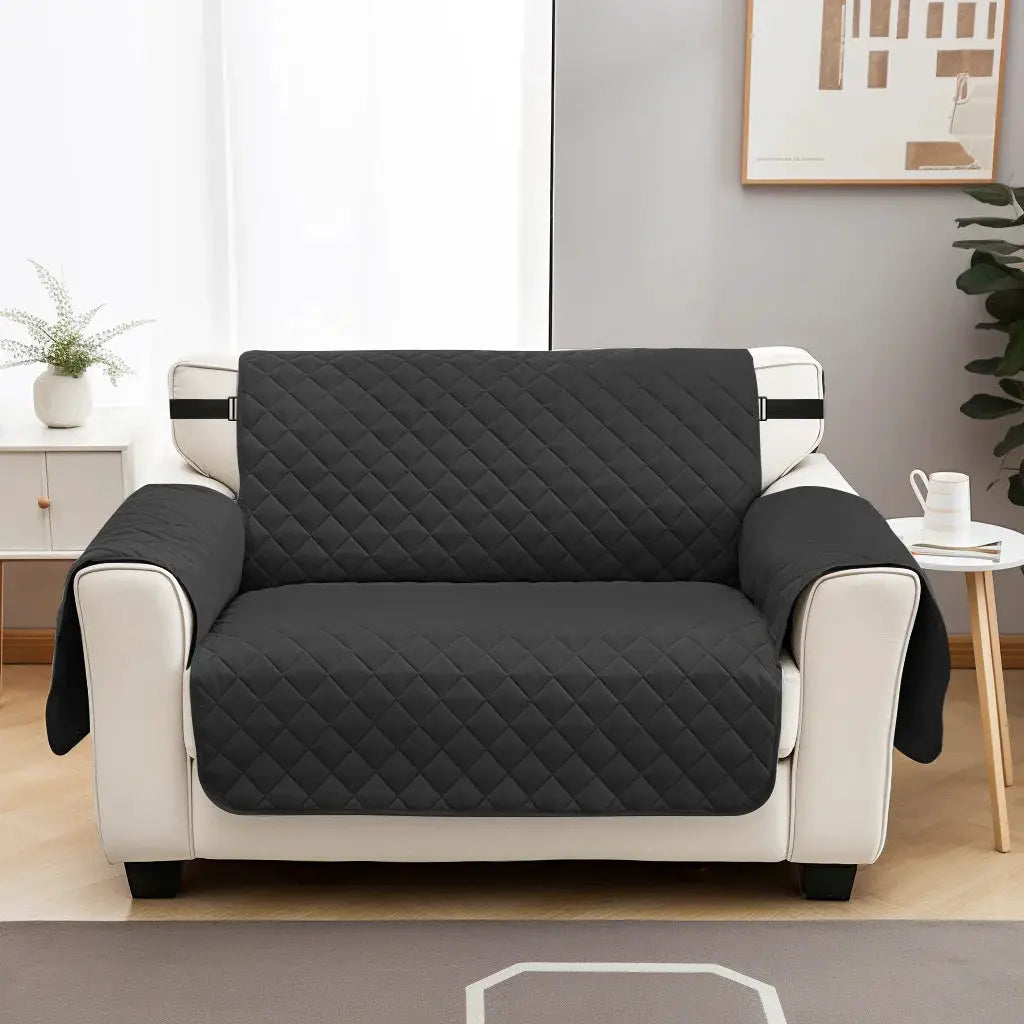 Sofa slipcover by Simples Market, black quilted waterproof cover with elastic straps on beige sofa