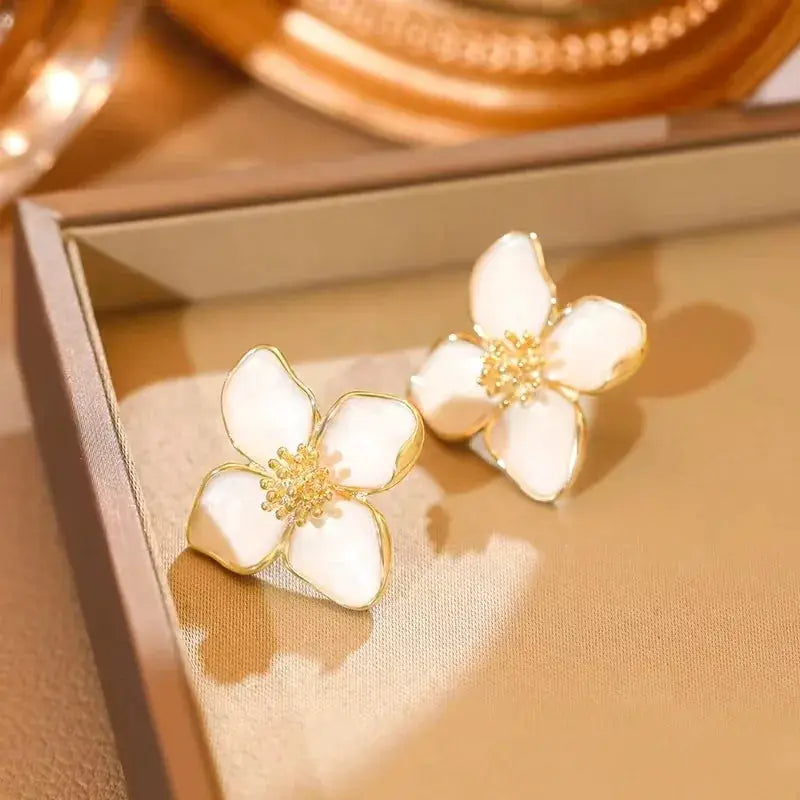 White enamel flower earrings by Simples Market with gold trim, pair