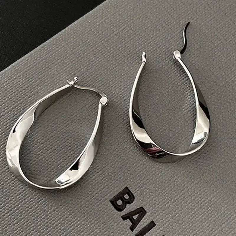 Teardrop hoop earrings, silver-tone with a polished metal finish; pair shown.