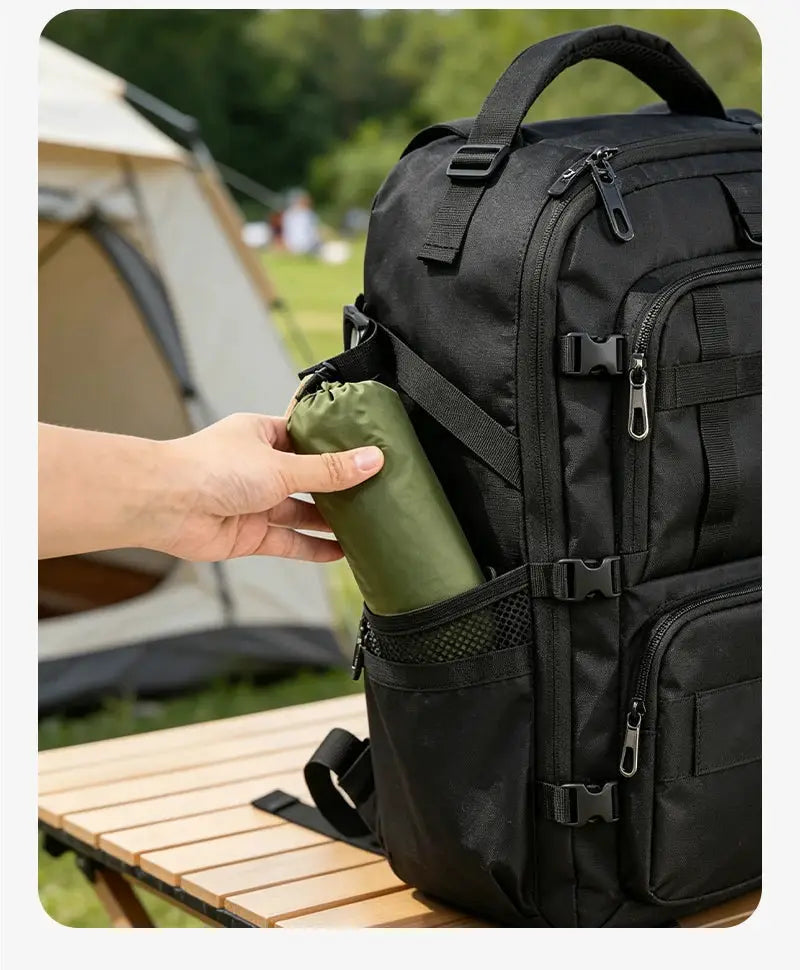 Ultralight sleeping bag liner, green stuff sack, placed into a black backpack