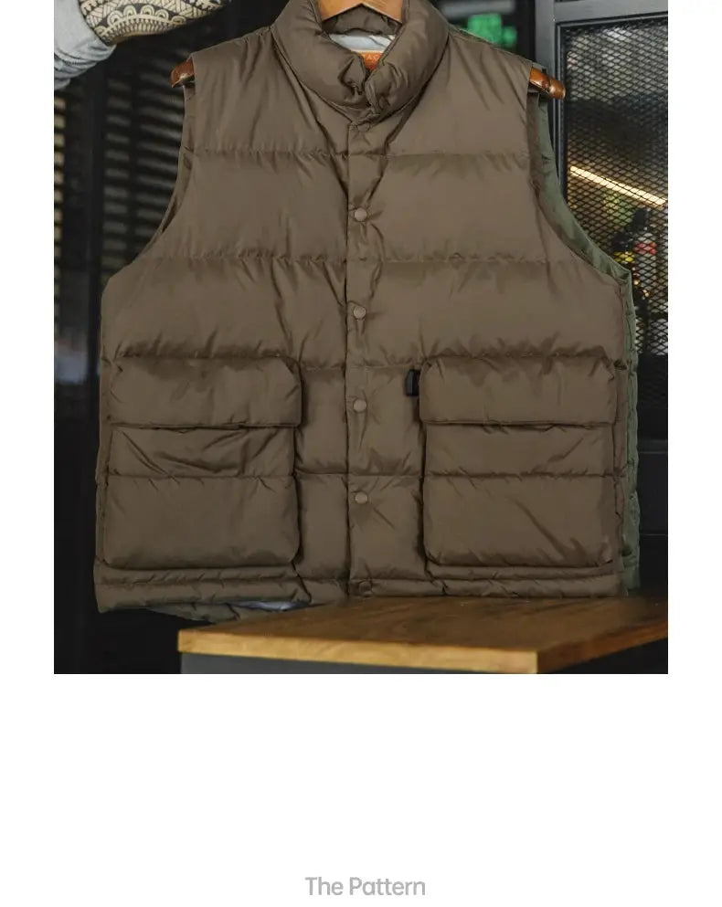 Maden men's brown down vest with stand-up collar, white duck down filling, and large double front pockets.